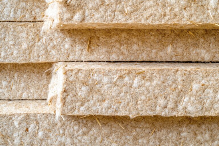 A close up image of hemp insulation panels. The panels are made of natural fibers and are stacked on top of each other.